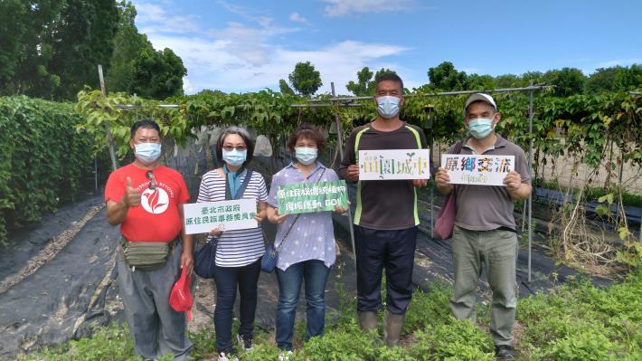 參訪團與原生好物農場畢英書在農場木虌果園前合影。