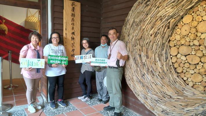 參訪團和吳雪月校長在野菜學校前合影。
