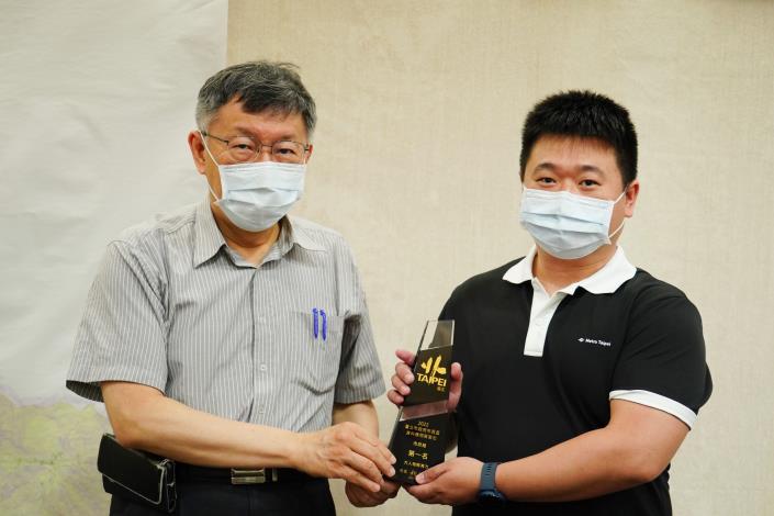 臺北市長柯文哲(左)頒發市府組第一名獎，臺北捷運員工(右)代表領獎。
