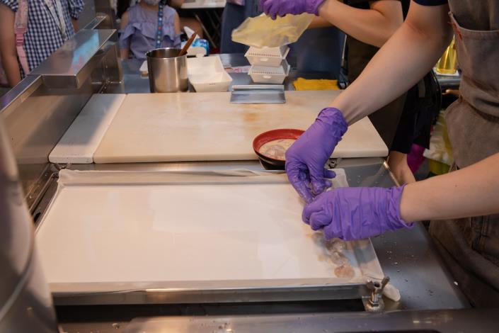 把米漿均勻的淋在紗布上後，就能開始把醃製過的餡料整齊地擺放上去。