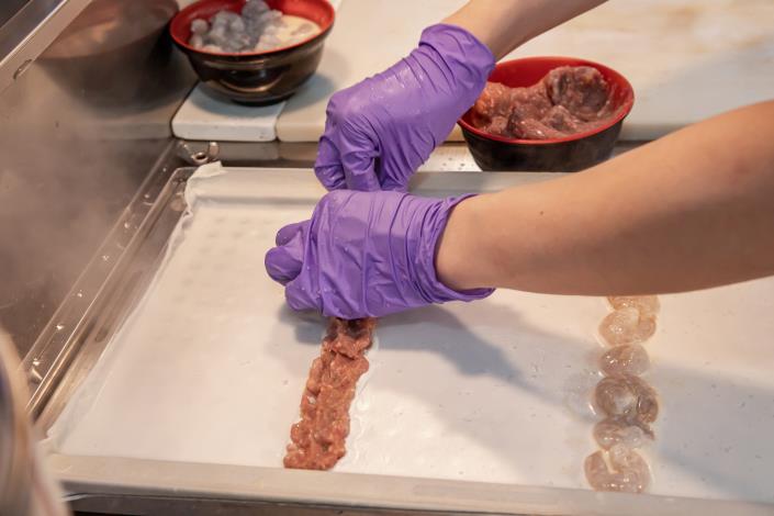 布拉式的腸粉在粉皮微微成形後，老闆會把事先醃製好的餡料一排排的擺上。