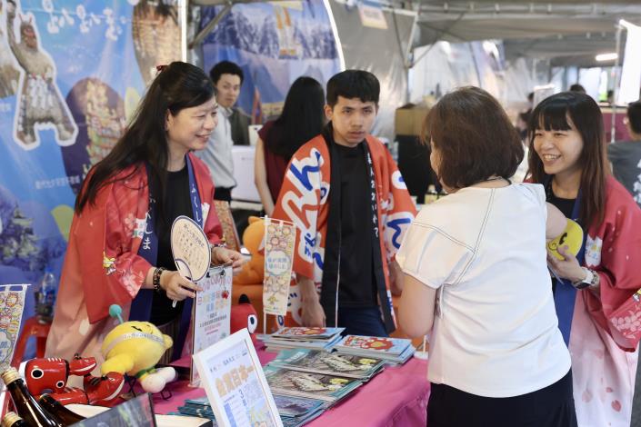 市集攤位人員向民眾熱情介紹遊程