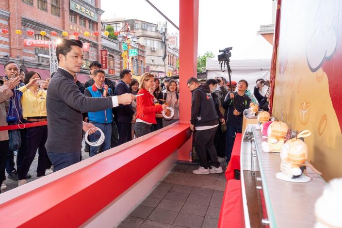 蔣萬安市長與英國在台辦事處代表包瓊郁一起挑戰「馬套成功」套圈圈遊戲