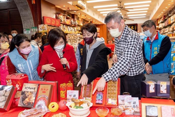 林亮君議員（左一）、主持人于美人（左二）、黃珊珊副市長（中）、徐慶棋理事長（右二）及陳炳甫議員（右一）向民眾介紹迪化街商圈特色年貨。