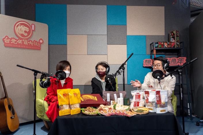 主持人于美人（左）及台北迪化商圈發展促進會陳仕哲總幹事（右）在街頭播音室與黃珊珊副市長（中）大聊年節必買年貨。