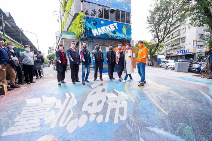 黃珊珊副市長、陳威遠理事長、阿芳老師、林崇傑局長、黃俊誠董事長及陳志芳總經理、江美玲副處長和呂勗淇里長於台北魚市立體彩繪人行道上合影留念。