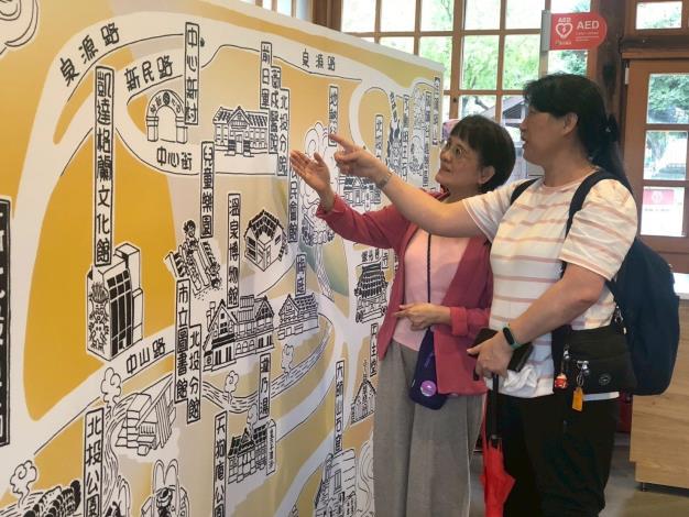 志工認直看新北投車站地圖介紹