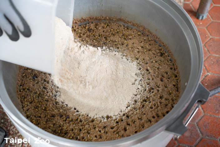 蒸煮完成的八寶米糕多道工序，還要加入大豆粉、奶粉等營養成分，也用來讓米糕可以不會太軟爛還可以塑型。