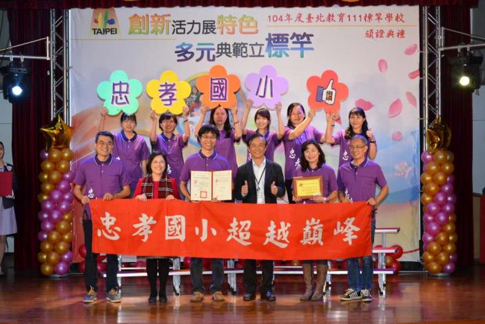 忠孝國小團隊歡喜領取標竿學校證書與獎牌