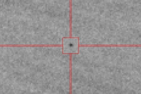 FuzzyGreyscaleImageWithRedCrossharisHighlightingDarkSpot_1024