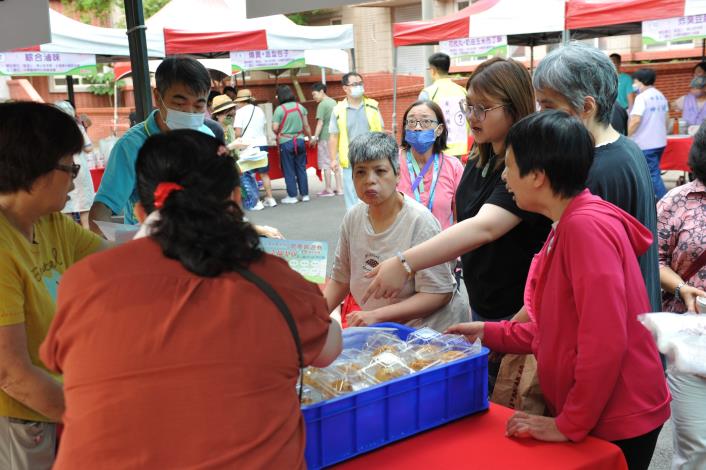 服務對象心滿意足地拿著園遊券兌換自己喜歡的攤位美食