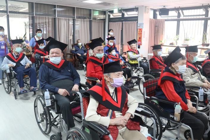 成2-養護區學員因坐輪椅，改披坎肩及戴學士帽-社工組.JPG