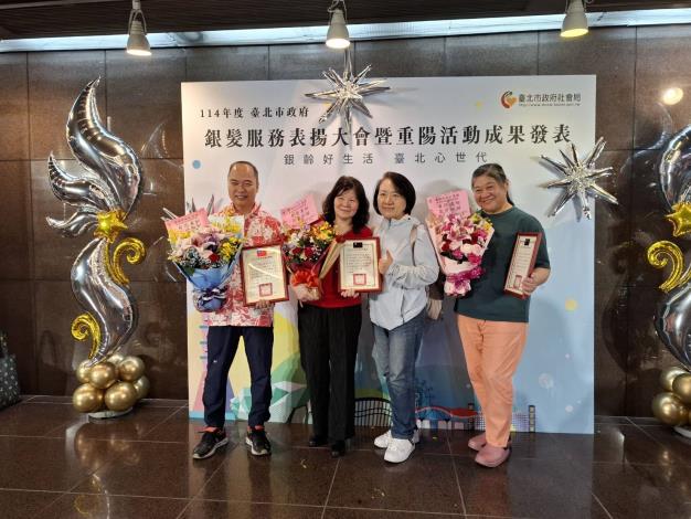 3.本院獲資深敬業獎之3位照服員-陳惠楸(左2)、黃鈺婷(右1)、陳國榮(左1)與本院致中敬老組組長一同與表揚大會背板合影。-社工組