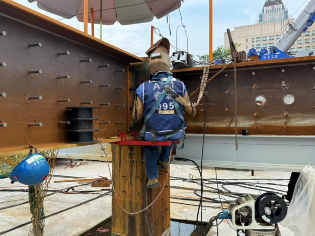 營造工地於柱頭電焊設置陽傘遮陽,使作業勞工在戶外也能安心工作。