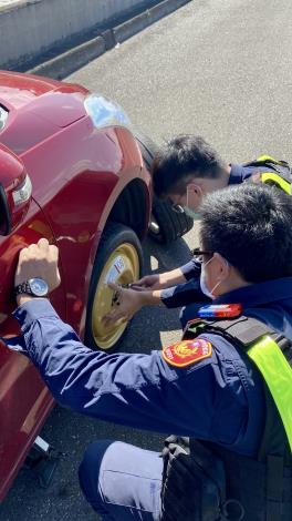 照片3-臺北市保安警察大隊員警主動伸出援手，協助該爆胎車輛駕駛更換備胎脫困。(jpg)