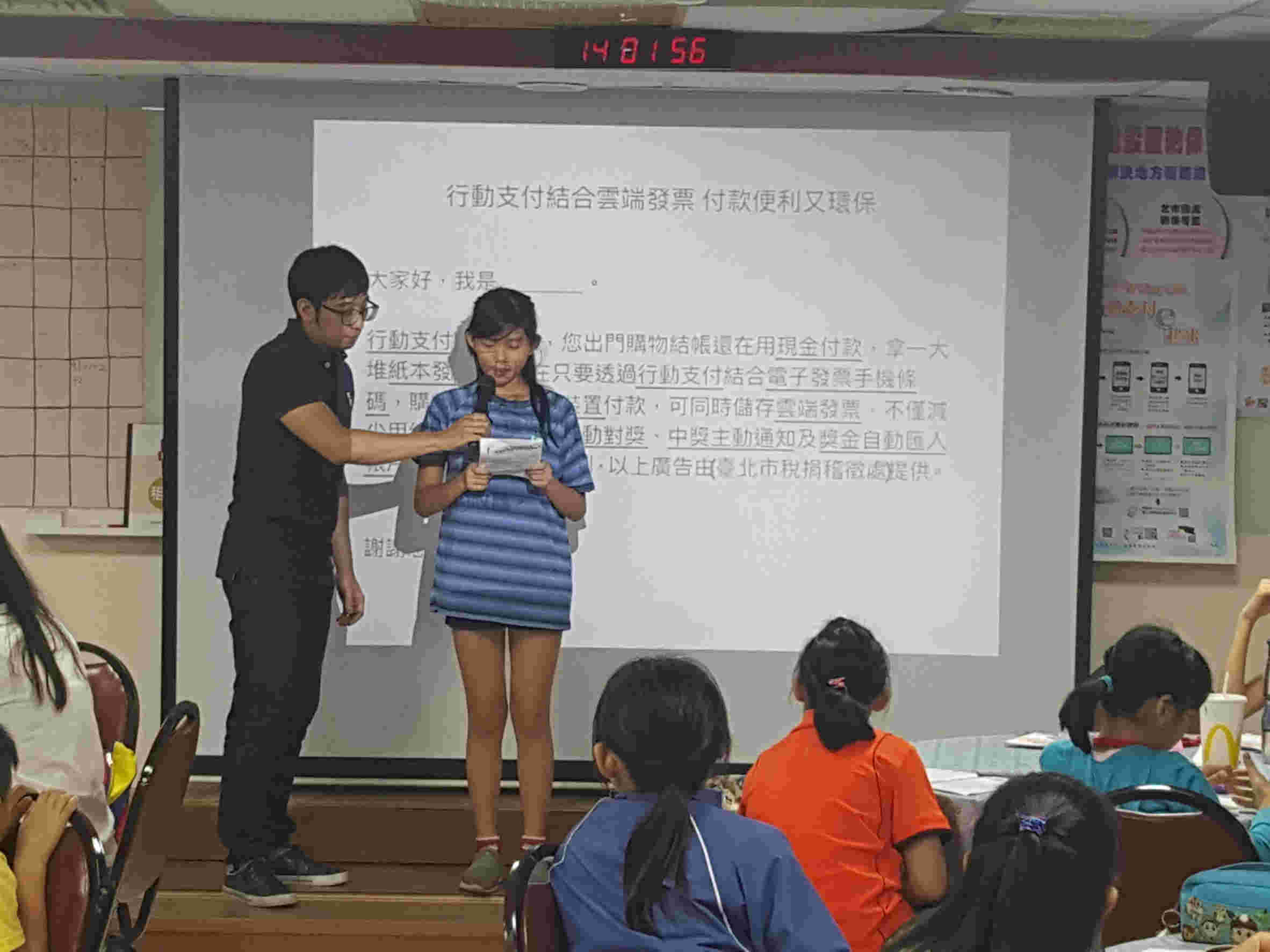 Boy and girl participants play broadcaster on stage