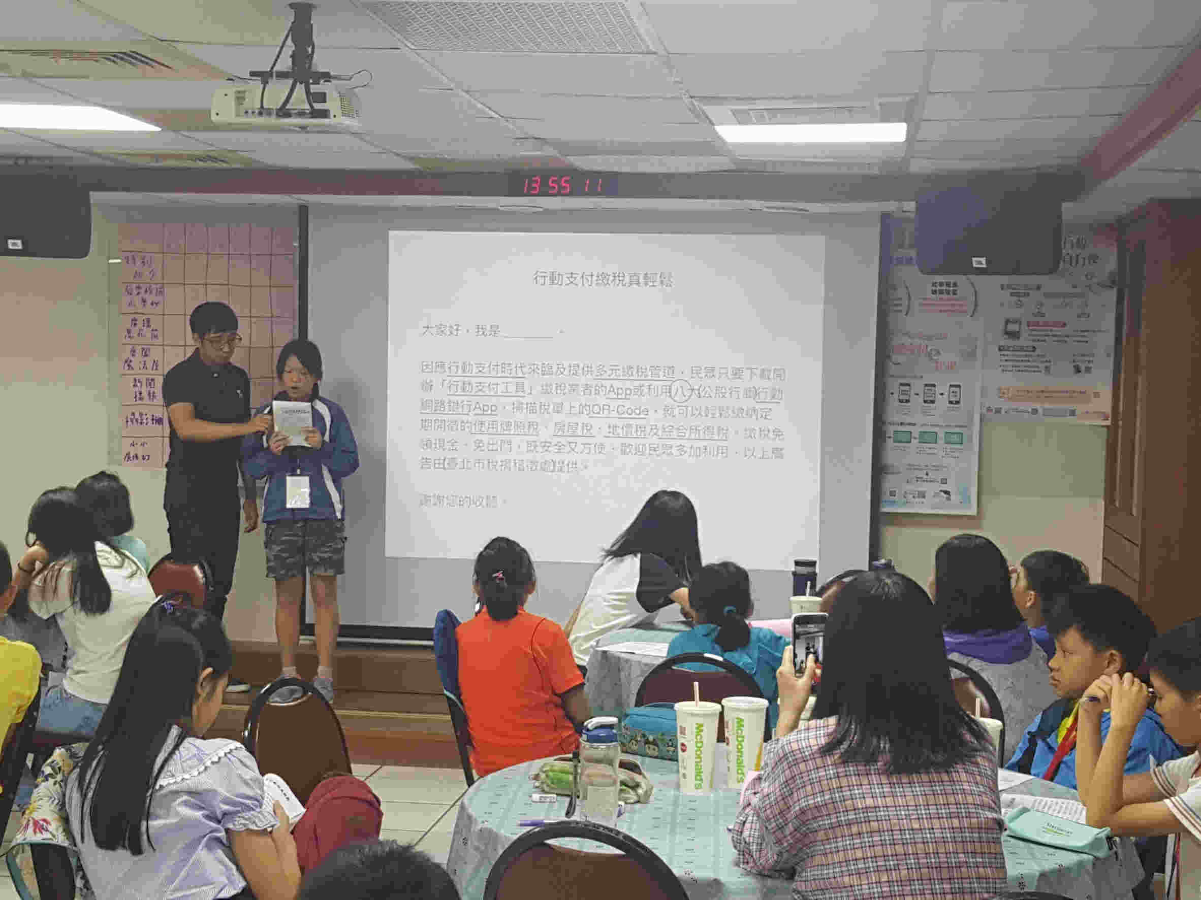 Boy and girl participants play broadcaster on stage