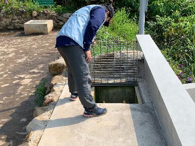 An expert inspects a deposit pond