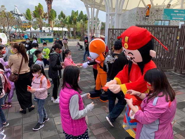 Staff dressed as God of Wealth passing out red envelopes to kids at TCAP