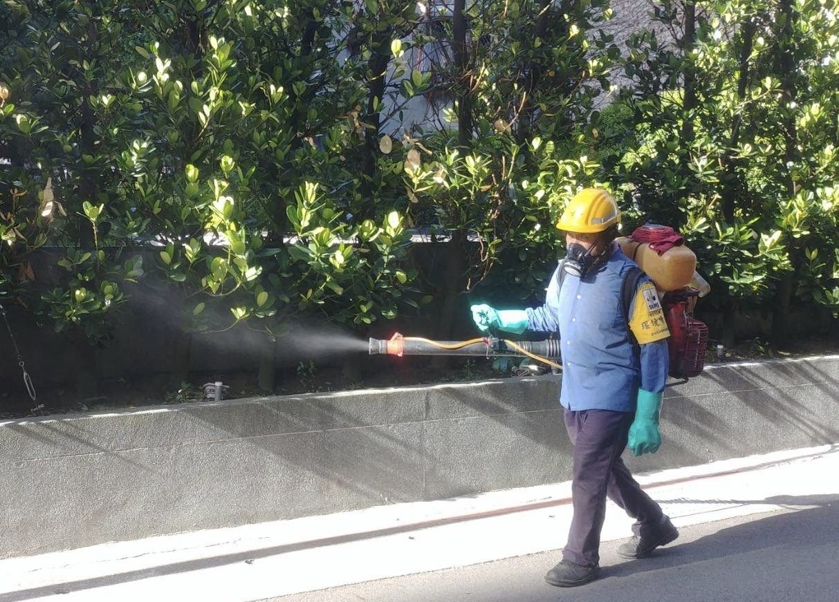 A worker carrying out disinfection of the surrounding