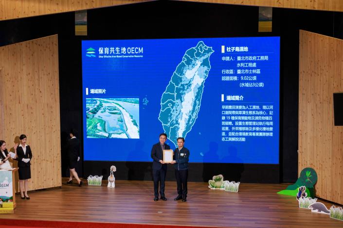 北市水利處的「社子島濕地」,成功獲得我國首屆「保育共生地(OECMs)」認證 (頒獎人(左)農業部林業及自然保育署署長林華慶致詞 受獎人(右)水利處主任秘書 林洙宏