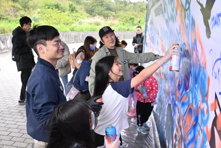 Commissioner Wei Yin of the Taipei City Government’s Department for Youth joins graffiti artists and children in a collaborative creation.