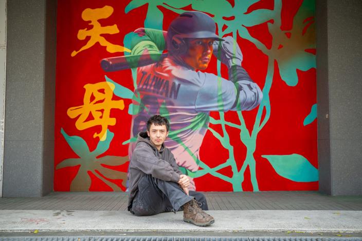 Graffiti artist ENOFone takes a photo with his artwork at Tianmu Baseball Stadium.