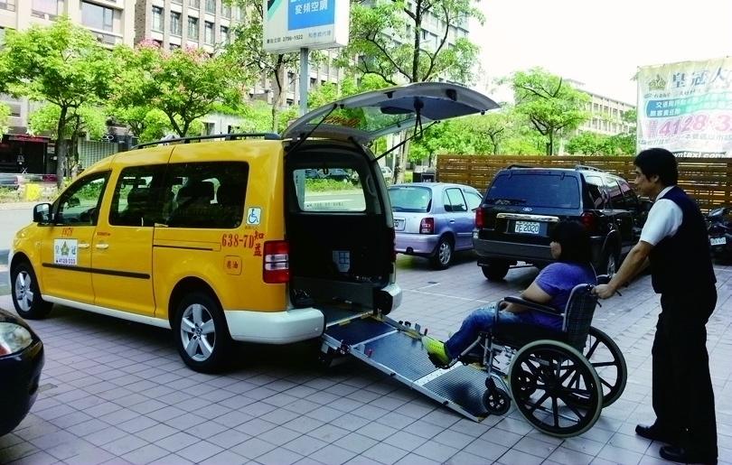 Assisting the people board a wheelchair-accessible taxi