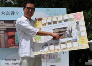 Liu Wei-gong, Commissioner of Department of Cultural Affairs, Taipei City Government, shows how to play the Monopoly game developed for the 2012 Taipei Heritage Day August 13.