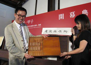 Taipei Cultural Commissioner Liu Wei-gong, left, displays the first Japonica rice sample in Taipei August 11, currently on view in a retrospective of Taipei’s history at Bopiliao Historic Block until September 28.