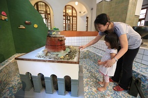 One piece of installation artwork in the smaller pool of the Beitou Hot Spring Museum in Taipei attracts a mother and her daughter. (Photo courtesy of the Department of Cultural Affairs)