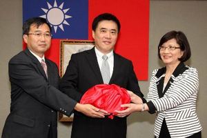 Tapei Mayor Hau Lung-bin, center, supervises when Chen Kuan-Fu, Deputy Commissioner of Department of Cultural Affairs, Taipei City Government, left, hands over the seal to newly appointed Commissioner Cheng Mei-hua, right, August 2 in Taipei.  