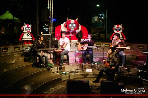 A band performs in from of the BIGPOW music player installation in the linear park of Zhongshan MRT Station