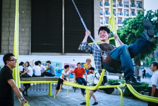 5. A young visitor to the Civil Swings Experimental Base on Aug. 10 tries to swing higher as his friend and members of Basurama lookon. (Photo courtesy of DOCA).