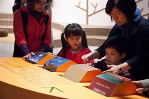 A mother, right, helps her son use an interactive device at the KoKo art exhibition, which will run through May 29, 2011. (Photo Courtesy of Taipei Fine Arts Museum)