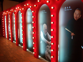 A hallway in the display area shows portraits of the masters.