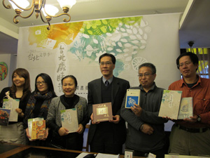 Hsieh Hsiao-yun, third from left, Commissioner of the Taipei Department of Cultural Affairs, and curators of the 2011 Taipei Literature Festival pose in front of the event’s poster.