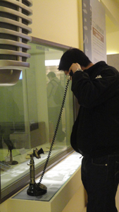 A visitor picks up the old style telephone and listens to interviews. (Photos by Eva Tang)