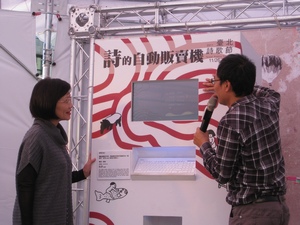 Cheng Mei-hua (left), Director of the Taipei Department of Cultural Affairs, and Hung Hung (right), one of the curators for the Taipei Poetry Festival, demonstrate how to use the “Automatic Vending Machine of Poetry” at the Thursday press conference in Taipei. (Photo by Yali Chen / Taiwan News)