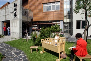 Visitors enjoy a pleasant reading time on the lawn outside the Kishu An Forest of Literature. 