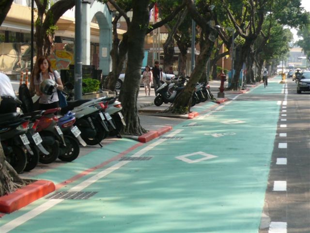 Motorbikes are allowed to pass across bike lanes and enter motorcycle parking bays by crossing the dotted lines on the right 