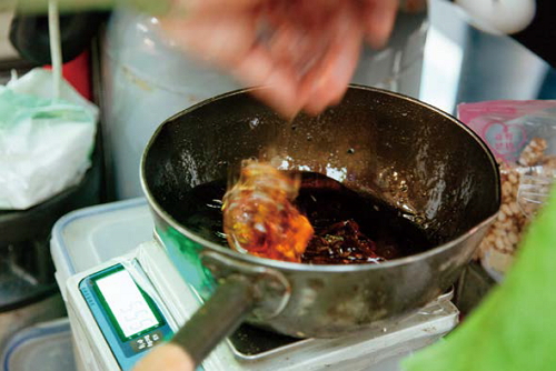 Maltose, which is used to hold the rice in place, is first melted in boiling water then mixed with the expanded rice.