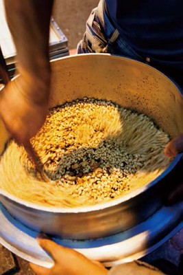 After the rice has expanded, maltose, mixed nuts, peanuts, and other ingredients are added. Each step must be quick and precise so that the process can be completed before the rice sets.