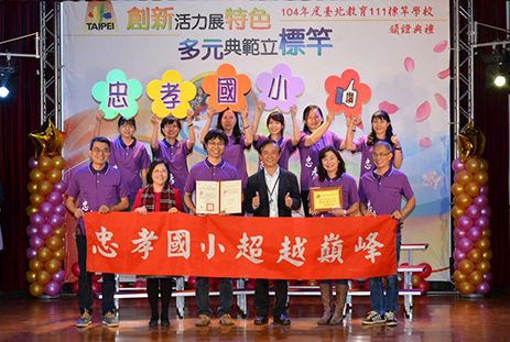 忠孝國小團隊歡喜領取標竿學校證書與獎牌