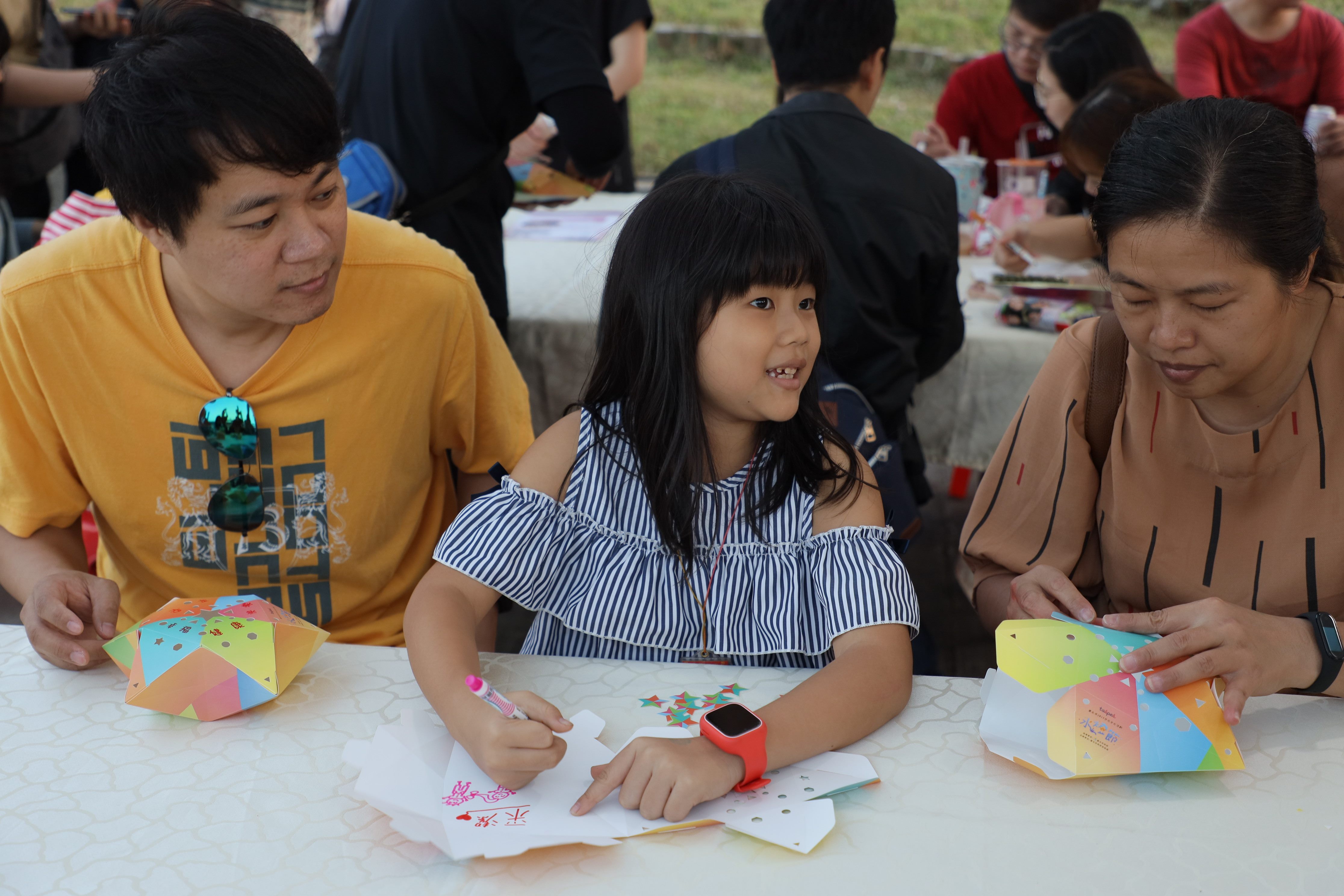 Adults and children making floating lanterns together