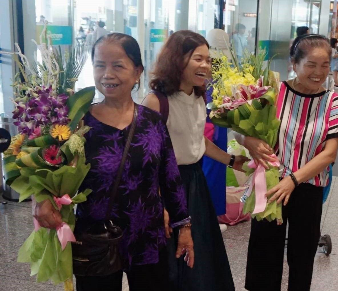 Vietnamese women smiling after receiving flowers for the Vietnamese Women’s Day