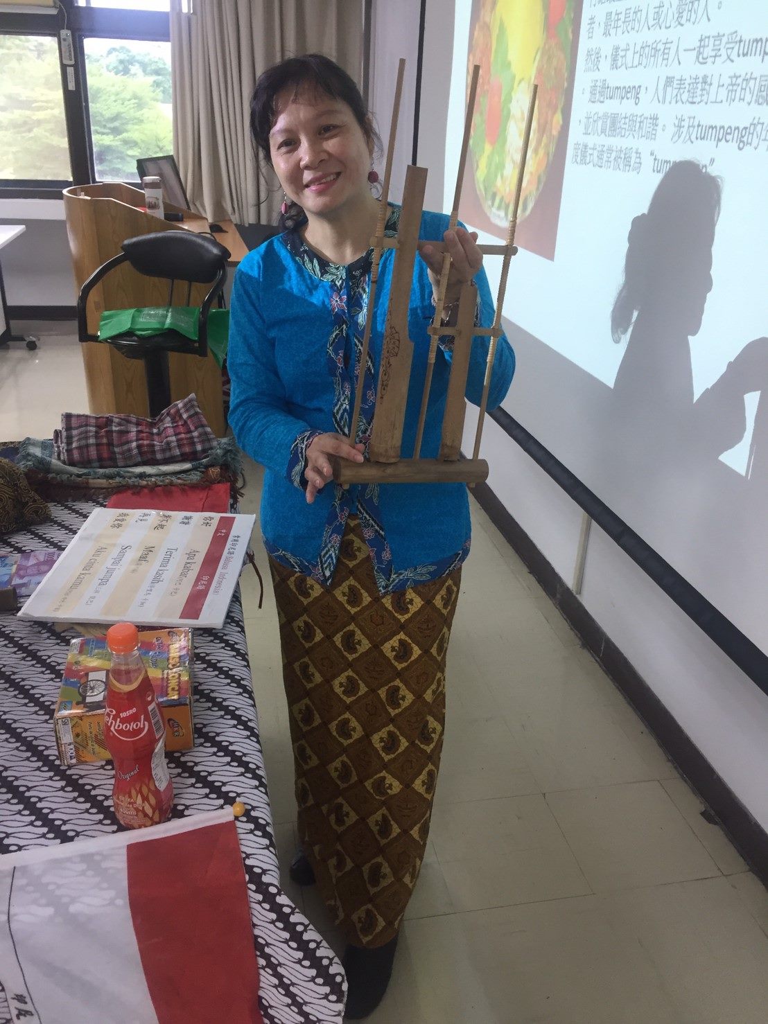 Indonesian lecturer demonstrating Indonesian traditional instrument: Angklung