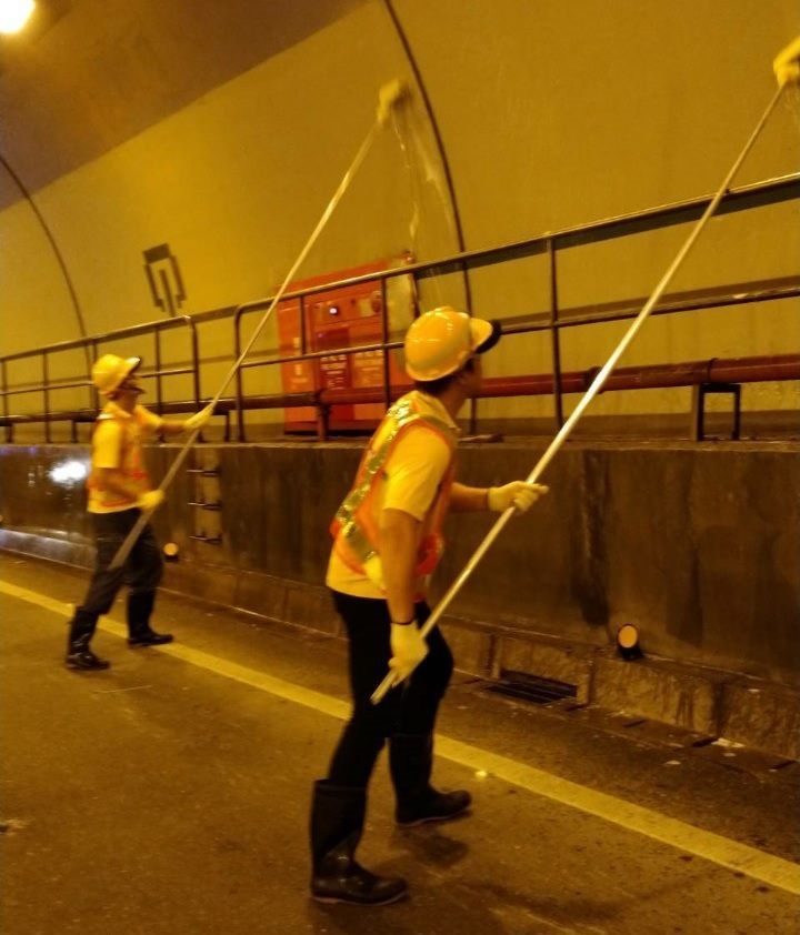 Workers cleaning the tunnel walls.