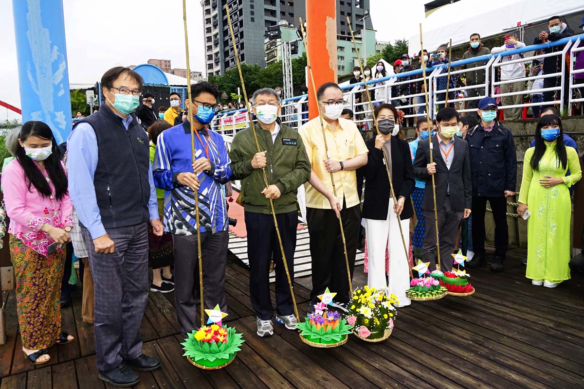 Mayor and dignitaries preparing to send off water lanterns into the river.