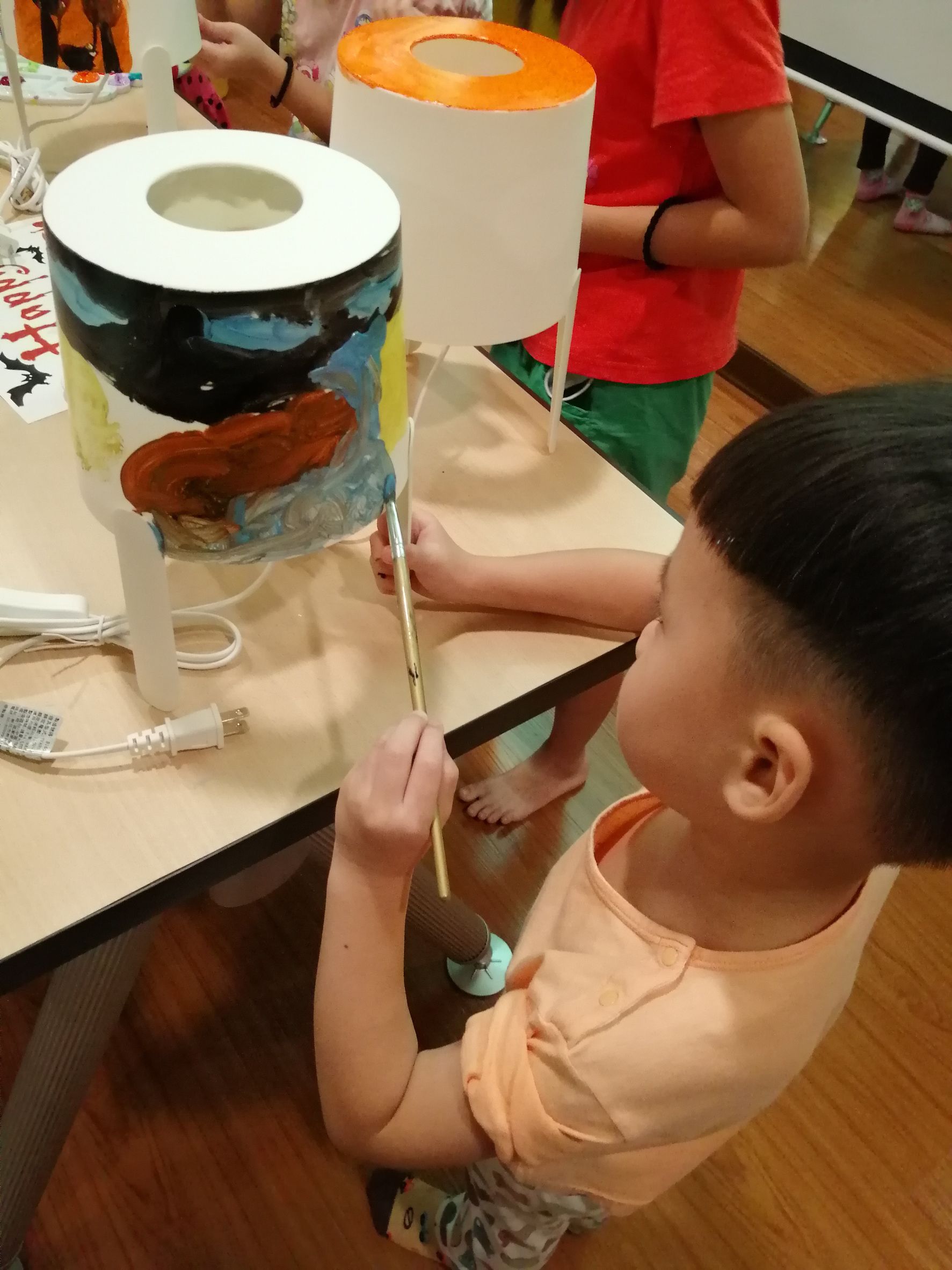 Students painting their own jack-o'-lantern.